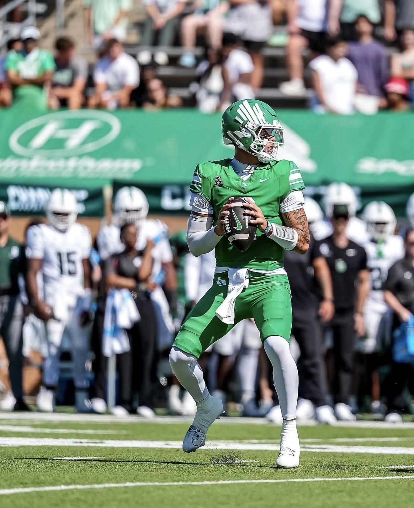 Tayven Jackson in his green North Texas football uniform carrying the ball during game action